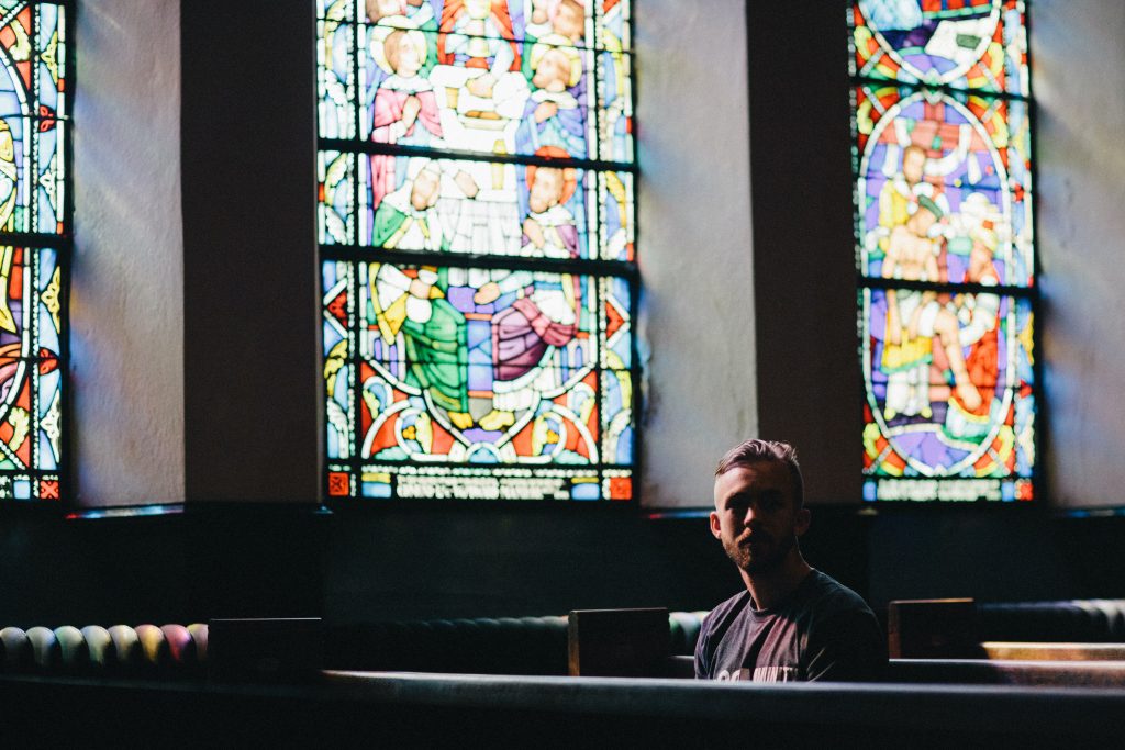 Man sitting alone in an empty sanctuary.