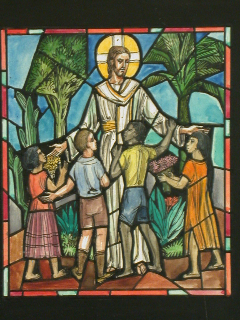 Stained glass image of Jesus blessing  children of different races.